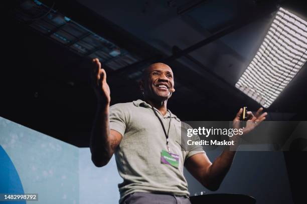 low angle view of excited male entrepreneur giving speech at tech event - orador fotografías e imágenes de stock