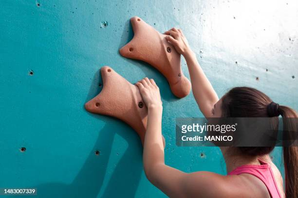 woman starting bouldering track on artificial wall - climbs to all time high stock pictures, royalty-free photos & images