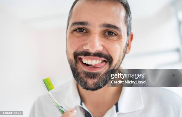 man smiling after brushing his teeth in a dentist's office - parodontitis stockfoto's en -beelden