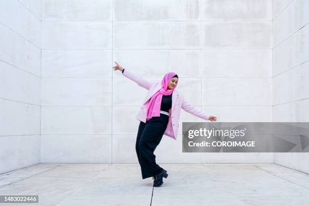 young muslim woman dancing with arms raised. - middle east cool stockfoto's en -beelden