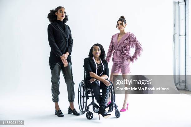 portrait of female fashion designer in wheelchair with female models - handicap photos et images de collection