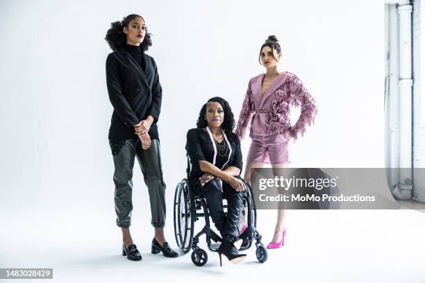 portrait of female fashion designer in wheelchair with female models - infinity cove stock pictures, royalty-free photos & images