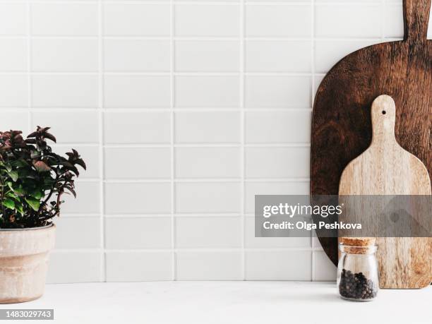 white kitchen background with kitchen utensils and green mint plant in pot - kachel stock-fotos und bilder