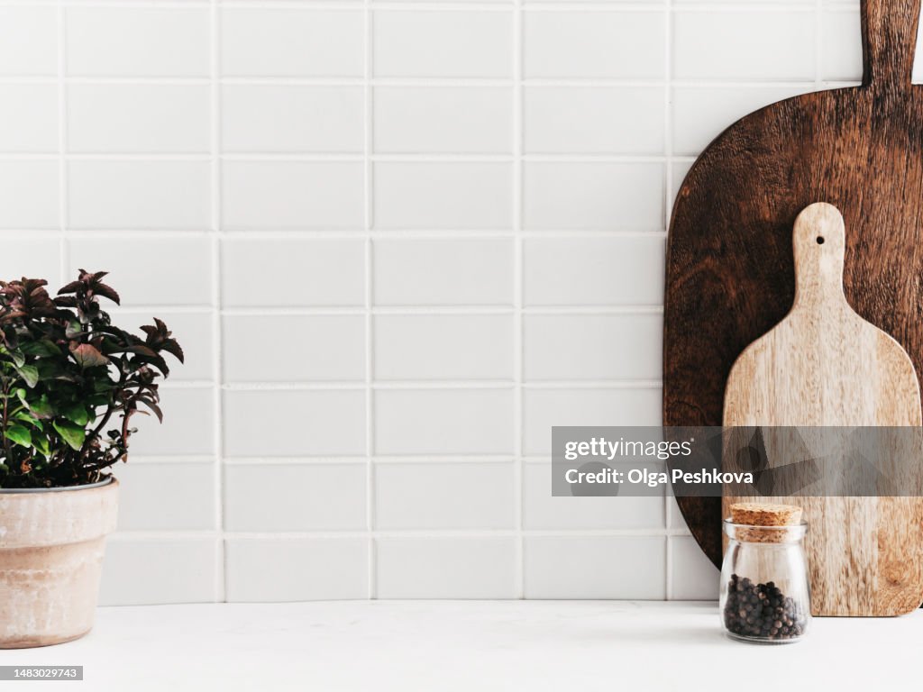 White kitchen background with kitchen utensils and green mint plant in pot