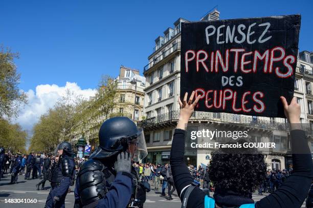 Police anti-émeute et pancarte "Pensez printemps des peuples" lors de la manifestation contre la réforme reculant l'âge de départ à la retraite à 64...