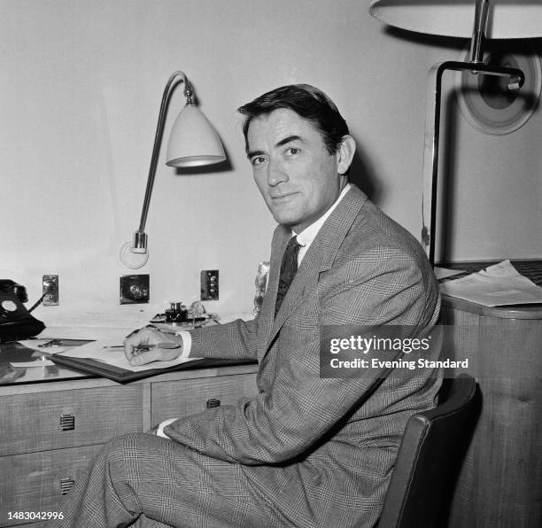 Actor Gregory Peck writing at his desk in London while promoting the film 'On The Beach', December 22nd 1959.