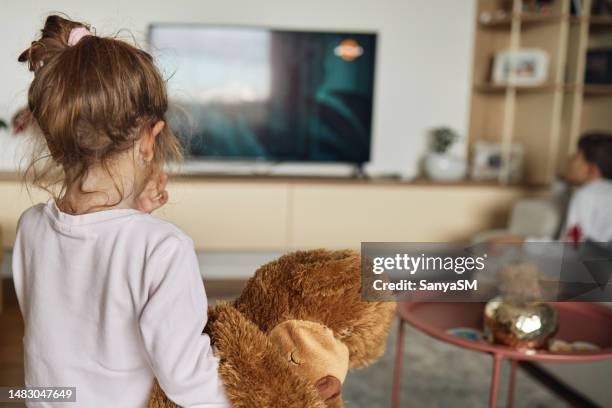 girl watching tv on sofa at home - day 2 stockfoto's en -beelden