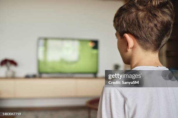 junge schaut zu hause auf dem sofa fern - hinterkopf stock-fotos und bilder