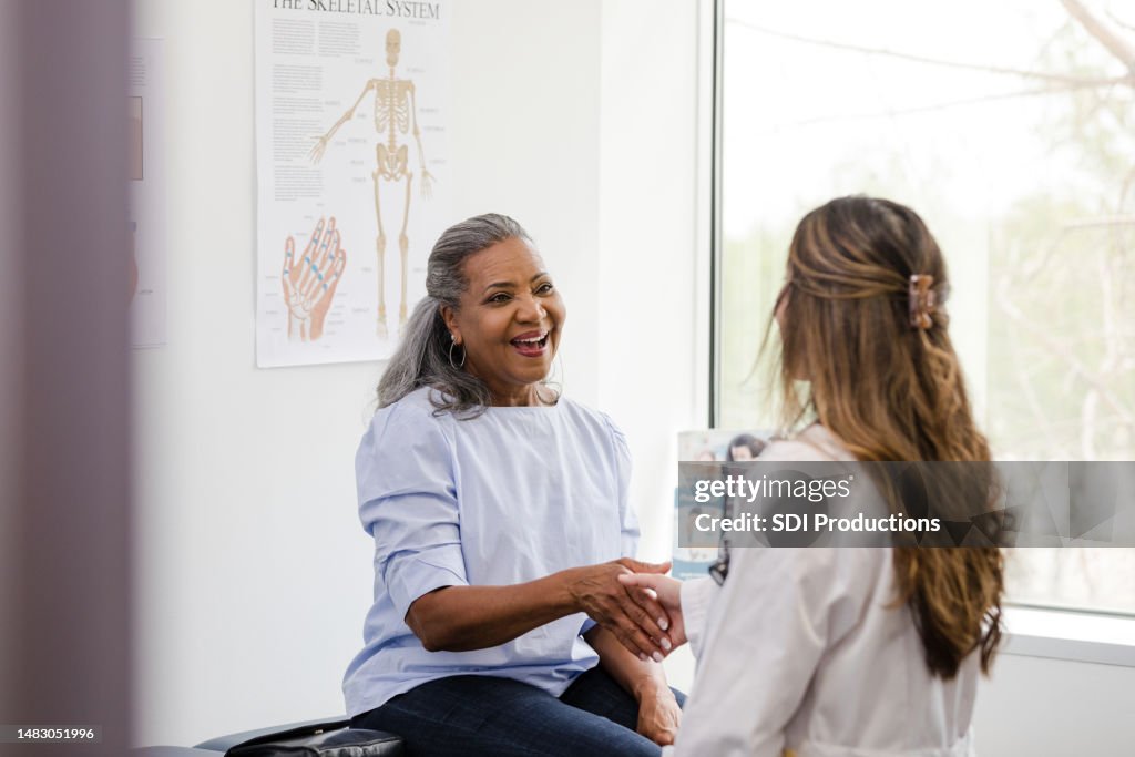 Patientin schüttelt der medizinischen Fachkraft die Hand