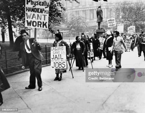Disability rights activists staging a protest outside Mayor LaGuardia's office at City Hall in New York on June 8th, 1935. One of the posters reads...
