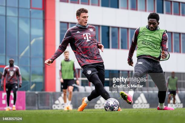 Benjamin Pavard of FC Bayern Muenchen passes the ball while being challenged by Alphonso Davies of FC Bayern Muenchen during the training session...