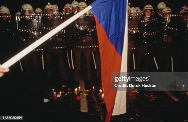 The flag of Czechoslovakia is held before riot police during a demonstration against the death of a student rumoured to have been killed by police,...