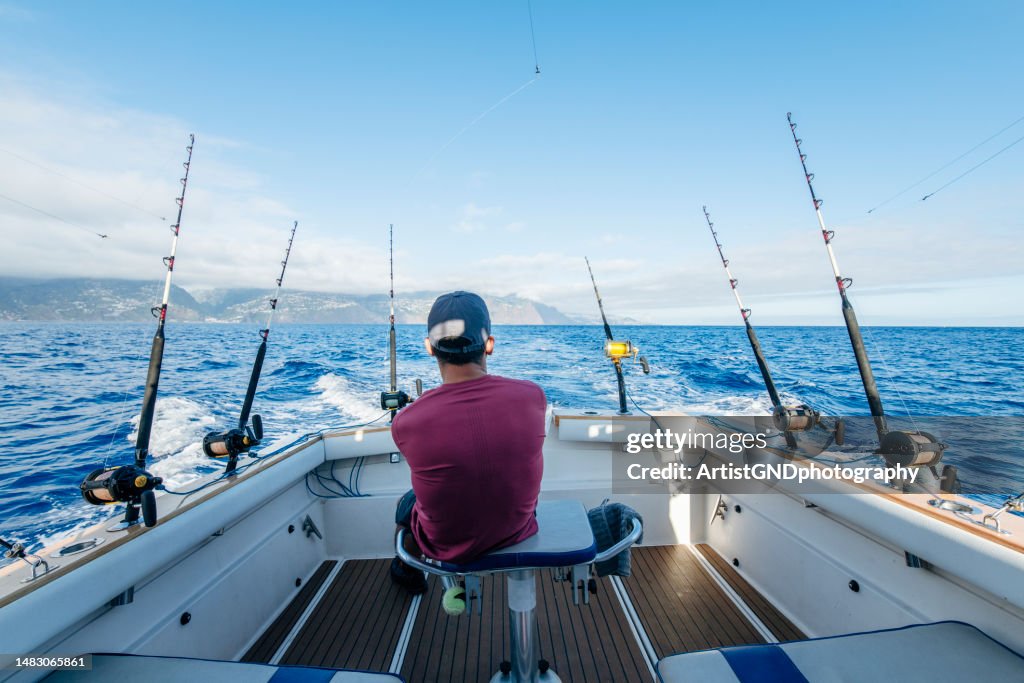 Mann auf einem Boot, das im Meer nach Thunfisch fischt.