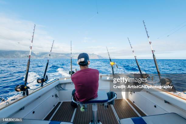 man on a boat fishing for tuna fish in the ocean. - trawler stock pictures, royalty-free photos & images