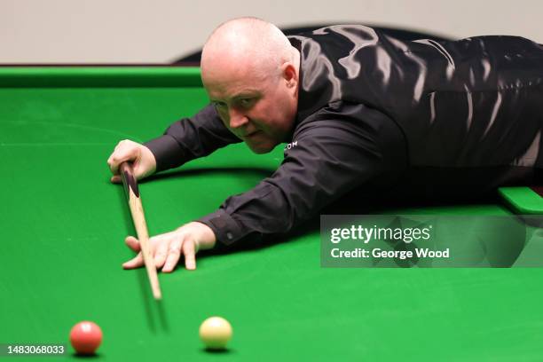 John Higgins of Scotland plays a shot during their round one match against David Grace of England on Day Four of the Cazoo World Snooker Championship...