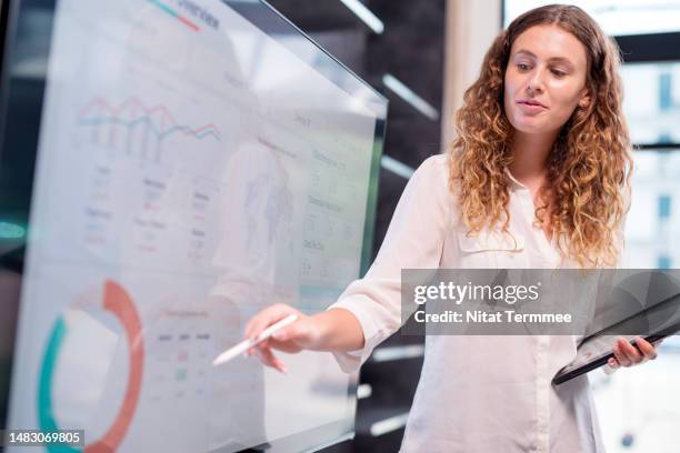 boost your sales and market margin to guarantee you always have more money coming in than going out with business financial planning and strategies. chief financial officer giving a presentation on the digital interactive screen to her teams in an office. - chief investment officer stock pictures, royalty-free photos & images