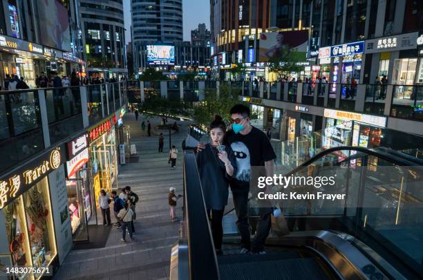 People ride an escalator as they shop in a busy retail shopping area on April 18, 2023 in Beijing, China. China's National Bureau of Statistics...