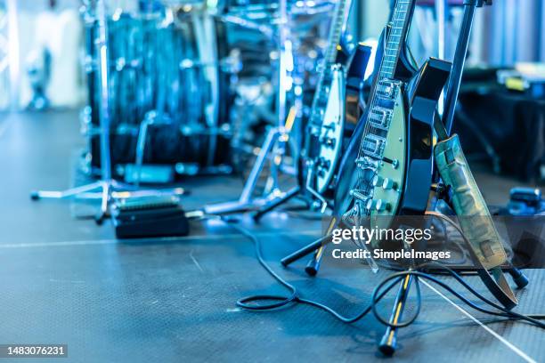 guitars placed on stands ready for guitarists before a concert. - pop music stock pictures, royalty-free photos & images