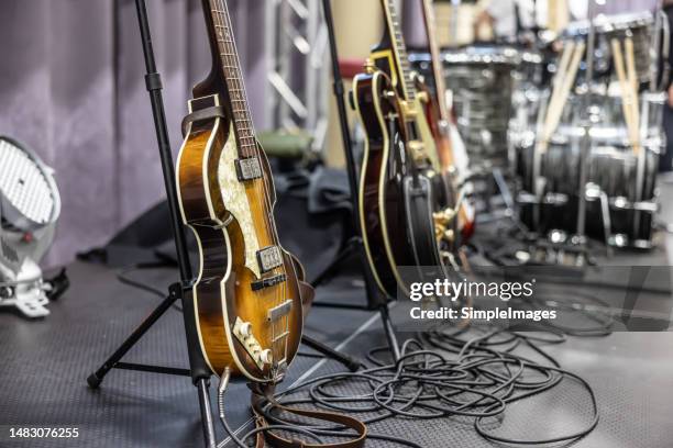 guitars placed on stands ready for guitarists before a concert. - música pop fotografías e imágenes de stock