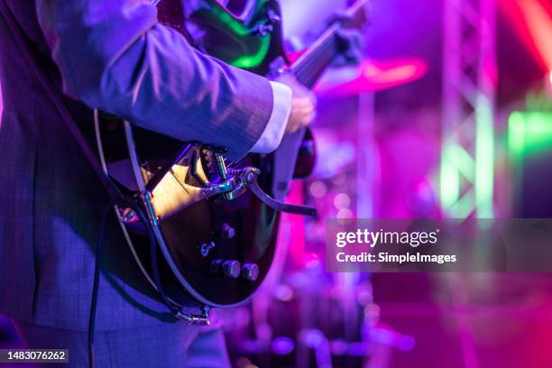 a guitarist plays at a rock or rock n roll concert. - blues stockfoto's en -beelden