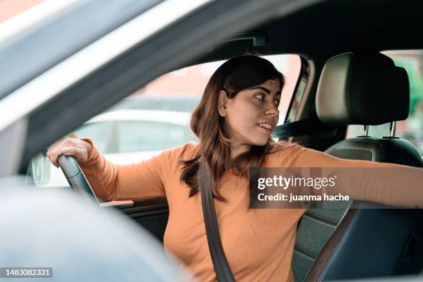 woman drives her car backwards - reverse stock pictures, royalty-free photos & images