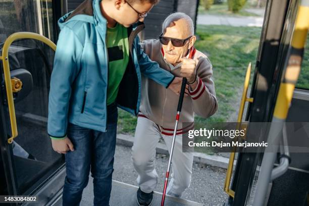 cieco attivo sale sull'autobus con il mantenimento dei bambini - nonni bastone foto e immagini stock