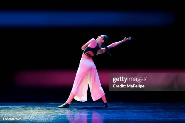 ragazza adolescente che balla danza contemporanea sul palco con luci colorate - contemporary dance foto e immagini stock