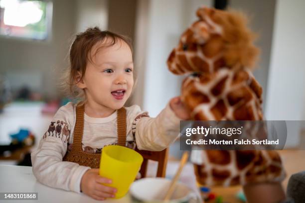 a girl playing with a puppet. - puppeteer photos et images de collection