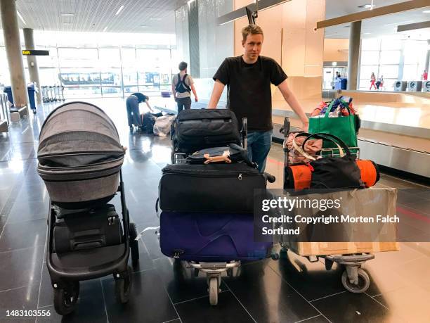 a man hauling luggage - carrito-para-equipaje fotografías e imágenes de stock