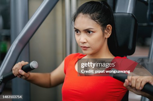 Pushing Body Machine Young Woman Exercising By Body Pushing Exercise Machine In Gym Fitness ...
