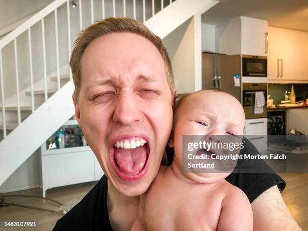 a funny moment of a new dad and his infant at home - funny baby faces stock pictures, royalty-free photos & images