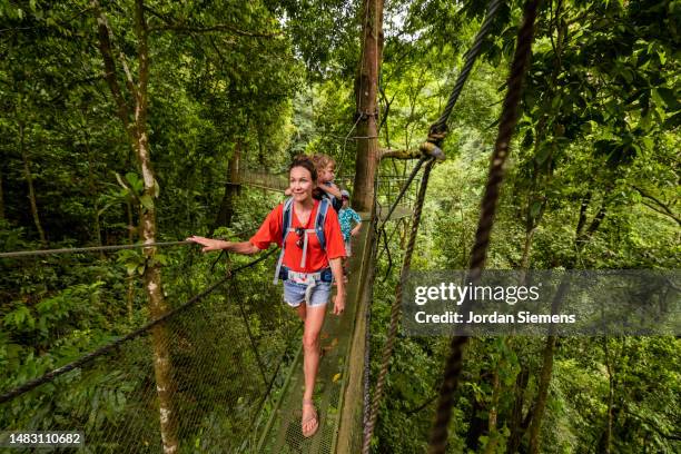 a family hiking hanging bridges in the jungle of costa rica - costa rica stock pictures, royalty-free photos & images