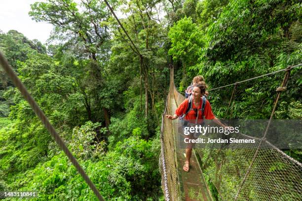 a family hiking hanging bridges in the jungle of costa rica - san jose costa rica stock-fotos und bilder