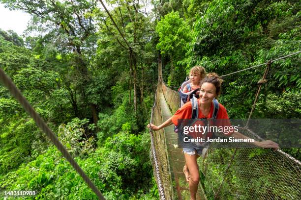 a family hiking hanging bridges in the jungle of costa rica - puntarenas stock pictures, royalty-free photos & images