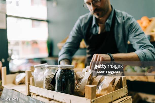 close up of a retail clerk in a organic grocery store - single seed stock pictures, royalty-free photos & images