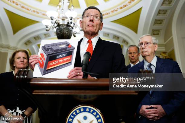 Sen. John Barrasso holds up an image as he speaks during a news conference following the Senate Republican weekly policy luncheons at the U.S....