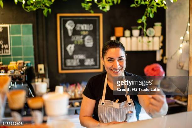 portrait of mature ice cream vendor on the store - ice cream shop stock pictures, royalty-free photos & images