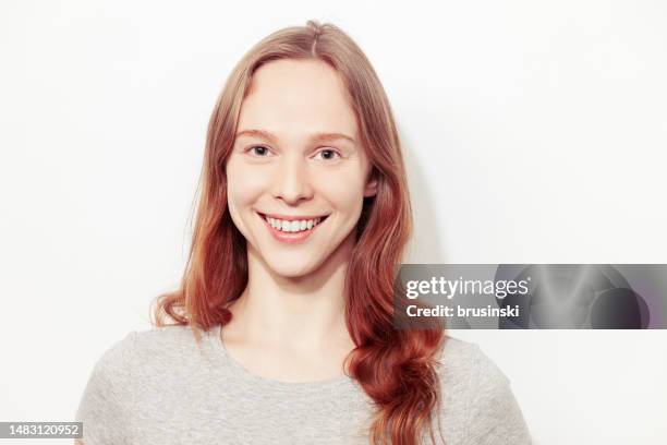 ritratto in studio ravvicinato di una giovane donna bianca felice con lunghi capelli castani su uno sfondo bianco - front flash photography foto e immagini stock