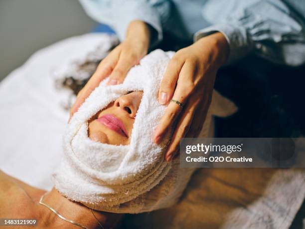 woman in a day spa receiving a facial treatment - hot korean women stock pictures, royalty-free photos & images