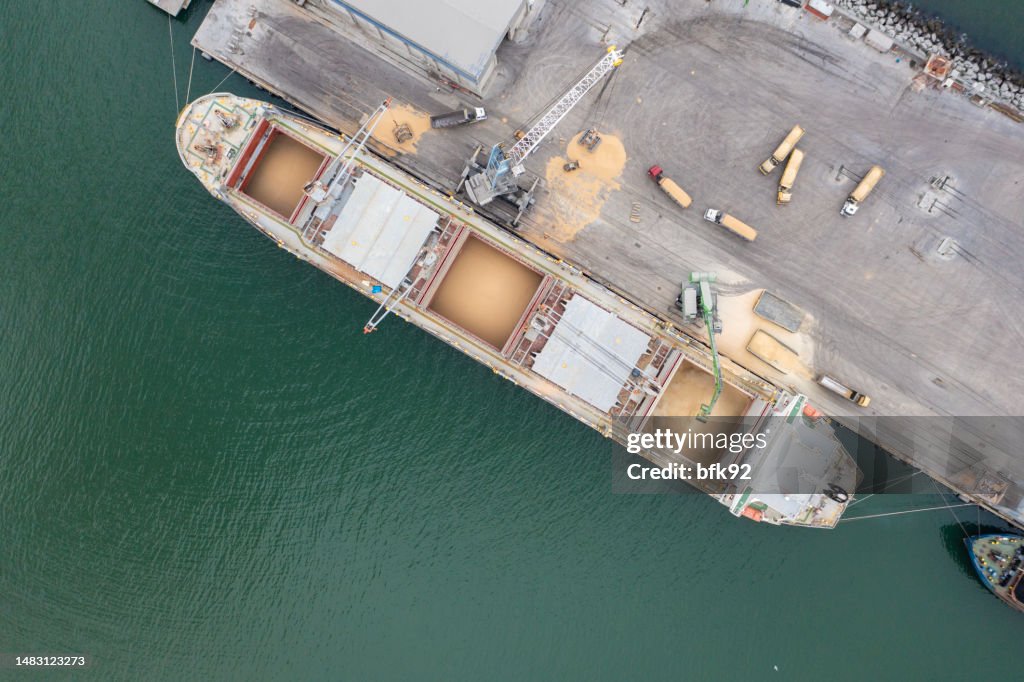 Carregamento de grãos em navio de carga marítima em porto comercial.