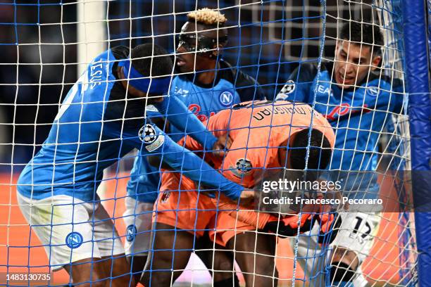 Mike Maignan of AC Milan holds onto the ball as players of Juan Jesus, Victor Osimhen and Giovanni Simeone of SSC Napoli attempt to regain possession...