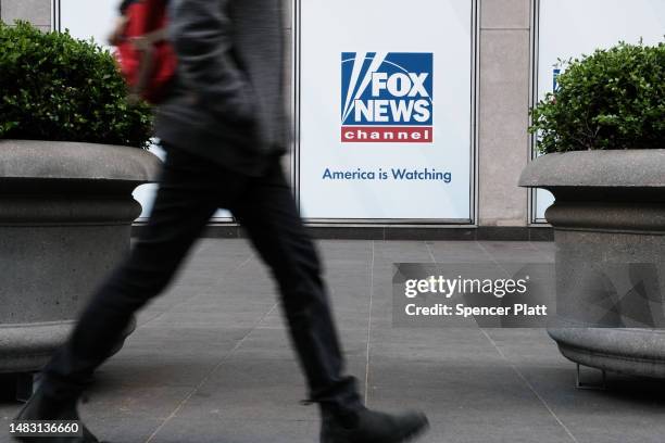 People walk by the News Corporation headquarters, home to Fox News, on April 18, 2023 in New York City. Moments before opening arguments were set to...