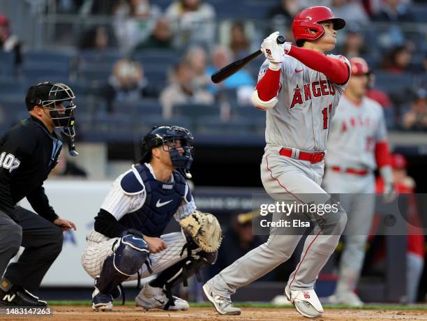 Shohei Ohtani of the Los Angeles Angels hits a two run home run in the first inning as Kyle Higashioka of the New York Yankees defends at Yankee...