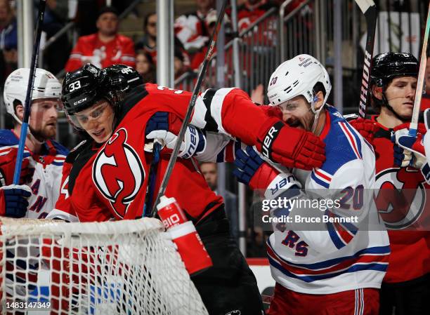 Ryan Graves of the New Jersey Devils and Chris Kreider of the New York Rangers get tangled up during the first period of Game One in the First Round...