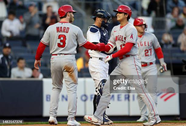 Taylor Ward of the Los Angeles Angels congratulates Shohei Ohtani after Ohtani drove them both home with a two run home run in the first inning...