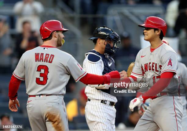 Taylor Ward of the Los Angeles Angels congratulates Shohei Ohtani after Ohtani drove them both home with a two run home run in the first inning...