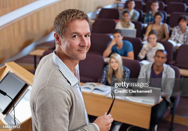 porträt eines lächelnden professor im podium mit university studenten - professor stock-fotos und bilder