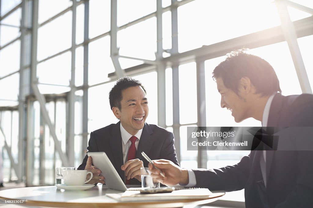 Hommes d'affaires à l'aide de tablette numérique dans les salles de réunion