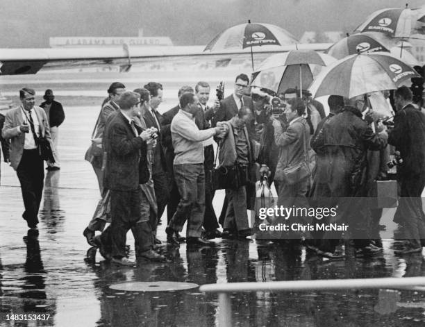 Dr Martin Luther King is greeted by reporters and sheriff deputies on the tarmac of Birmingham Airport as he returns to report to jail after losing a...