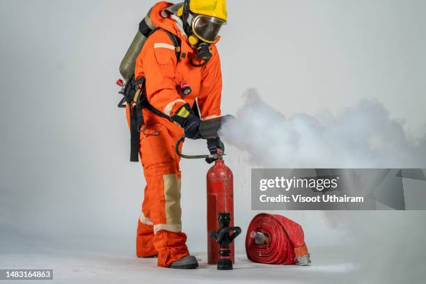 firefighter with mask and protective suit on a white background. - fireman uniform stock pictures, royalty-free photos & images